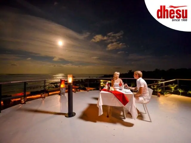 A private candlelit dinner table set on a clifftop at dusk