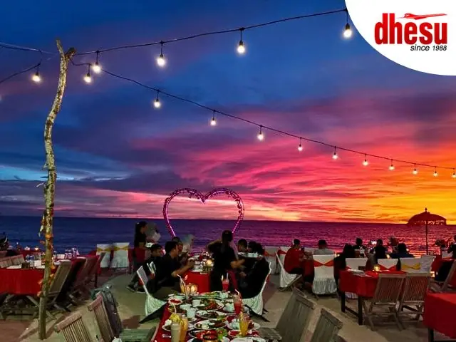 Romantic candlelit seafood dinner on Jimbaran Bay beach at sunset, Bali