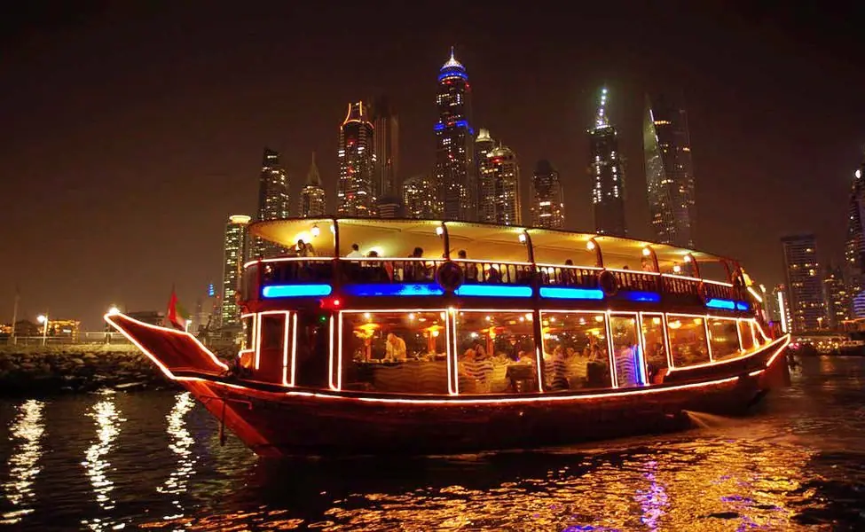 A lantern-lit dhow cruising past the Dubai Marina skyline