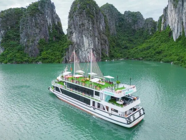 A multi-deck cruise ship at anchor in a sheltered bay