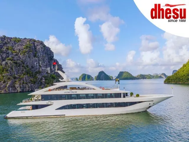A white cruise ship sailing past limestone islands