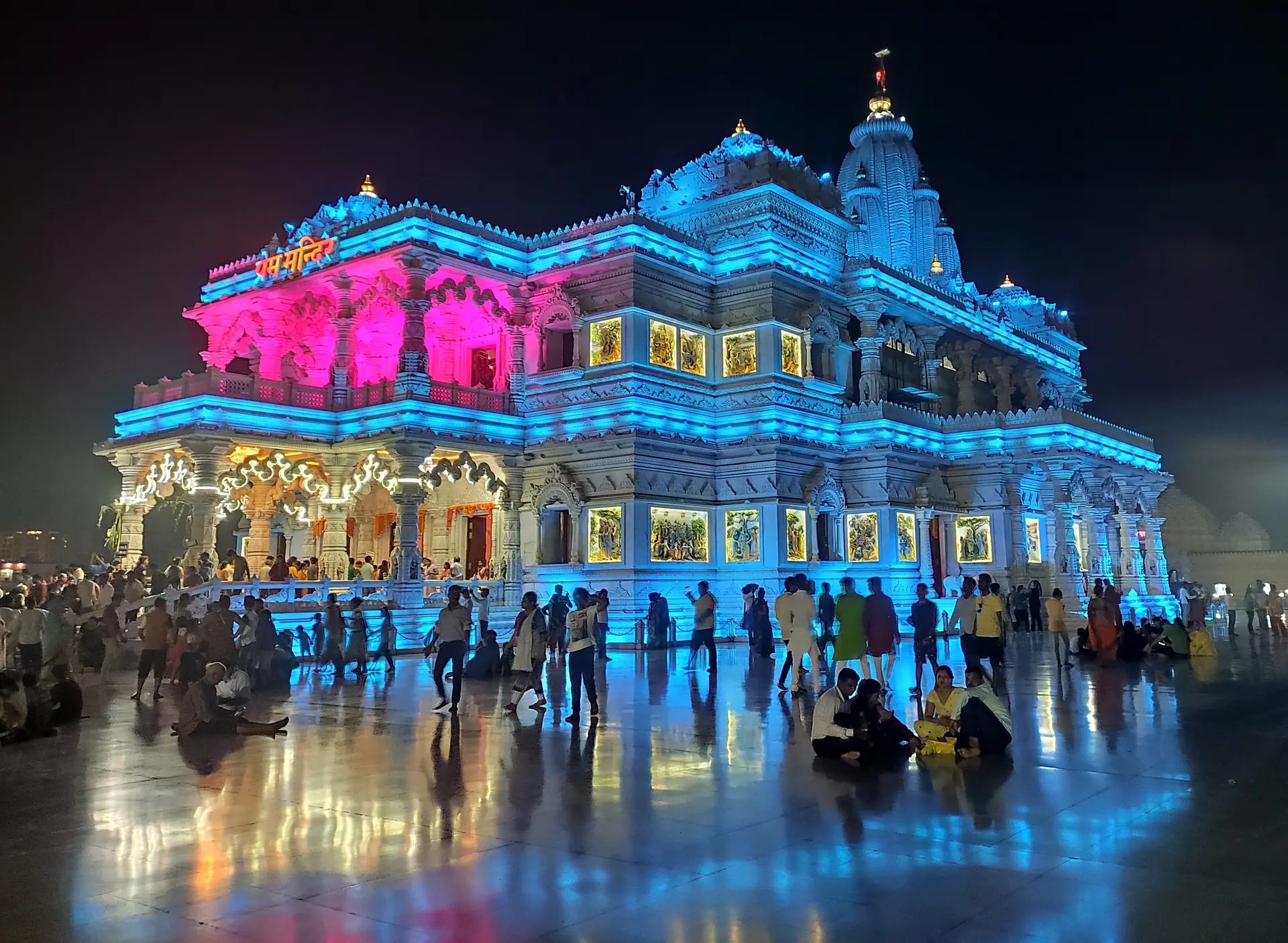 An illuminated temple reflected in water after dark